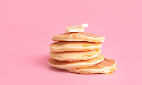 A stack of pancakes with butter on top