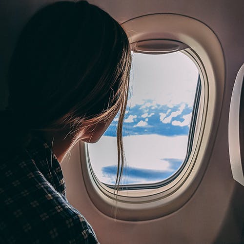 Woman looking out plane window