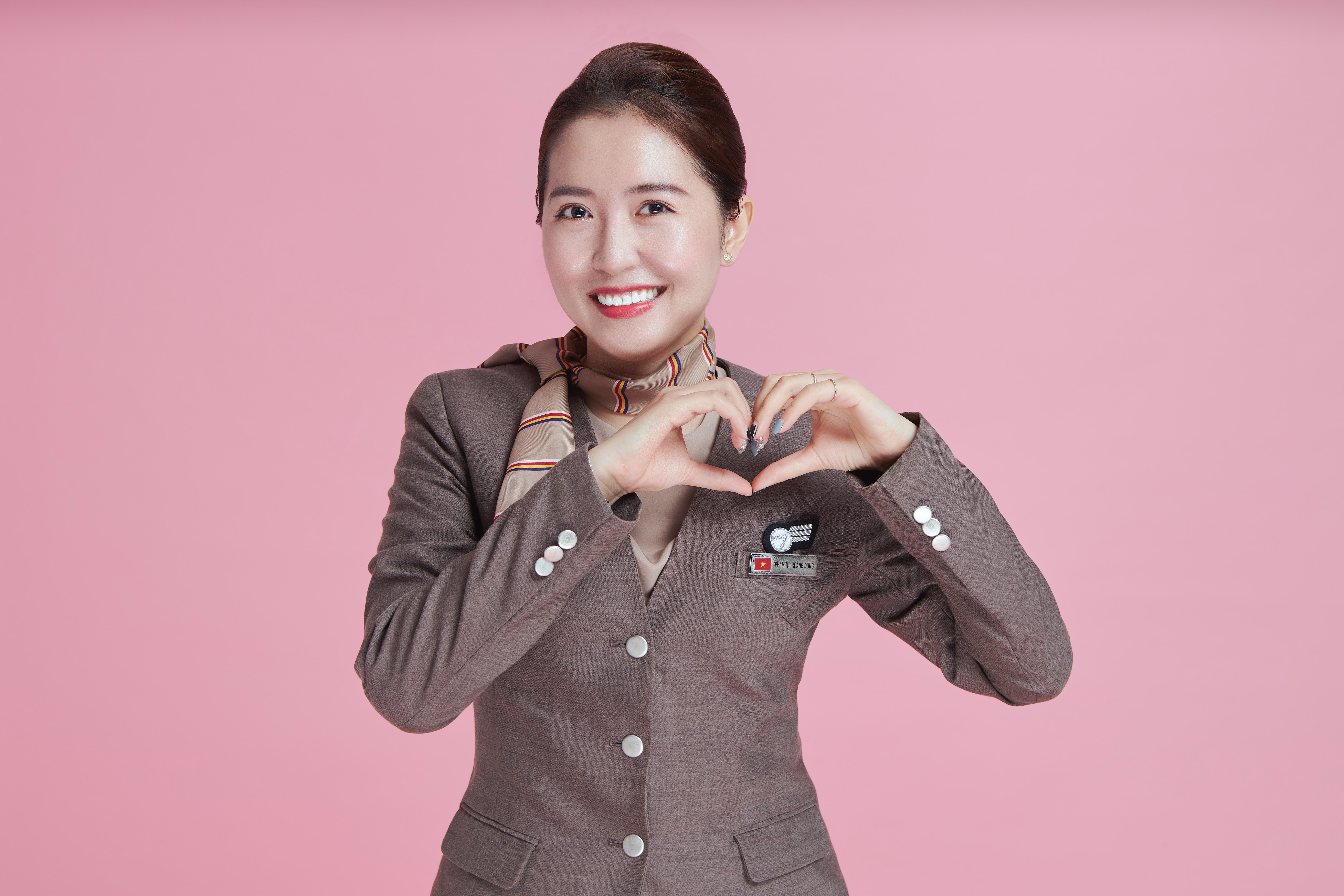 Asiana Airlines flight attendant with a pink background