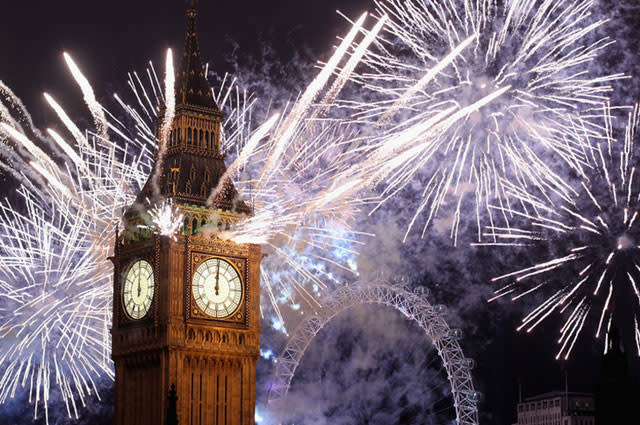 colourful and bright fireworks lighting up London's Big Ben and London Eye at New Year