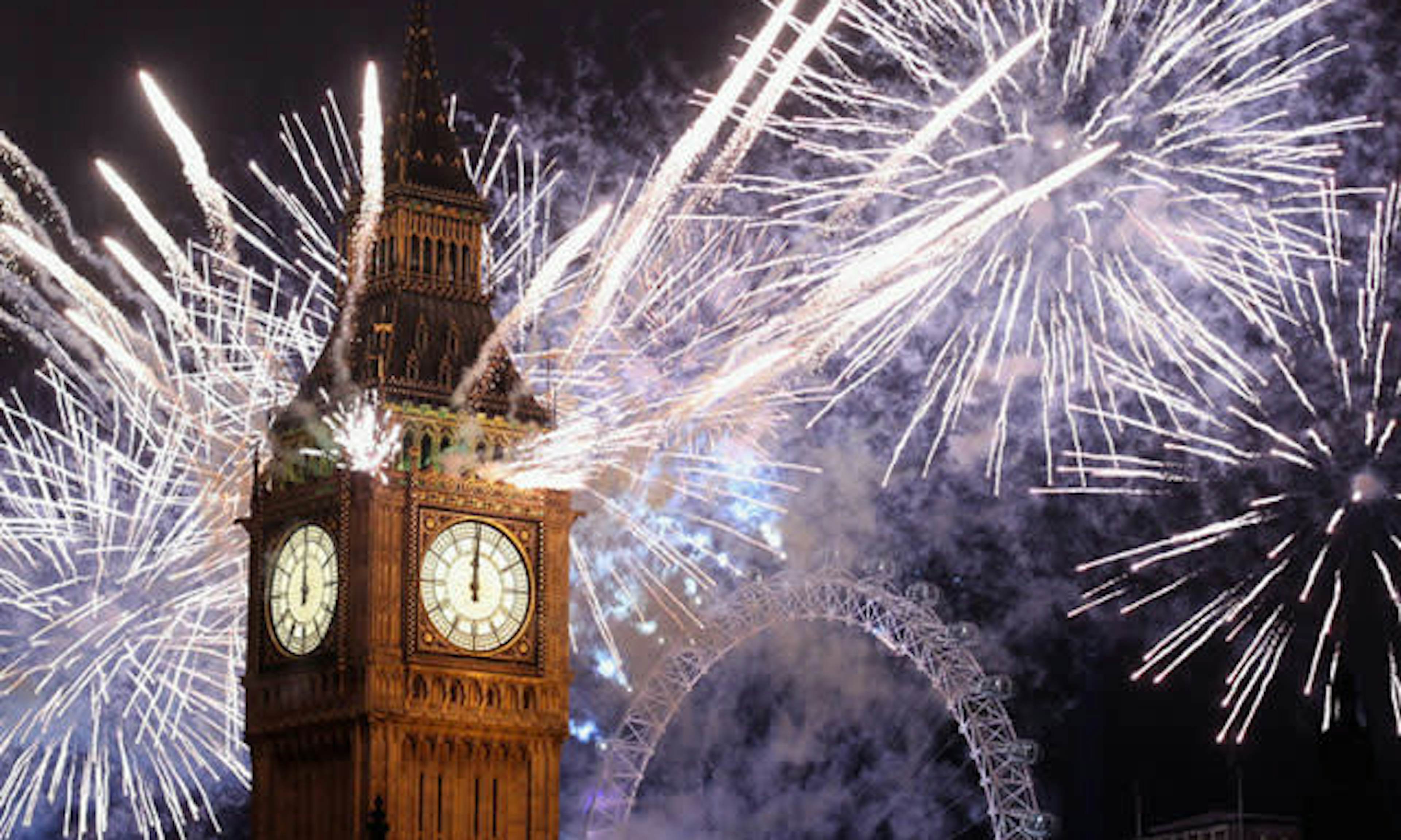 colourful and bright fireworks lighting up London's Big Ben and London Eye at New Year