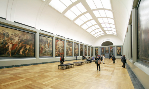 View inside an art gallery with the public looking at paintings