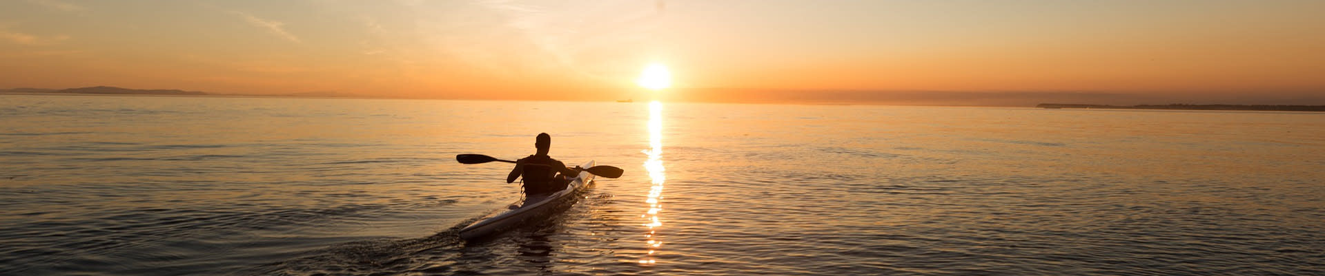 man on a kayak in the sunset