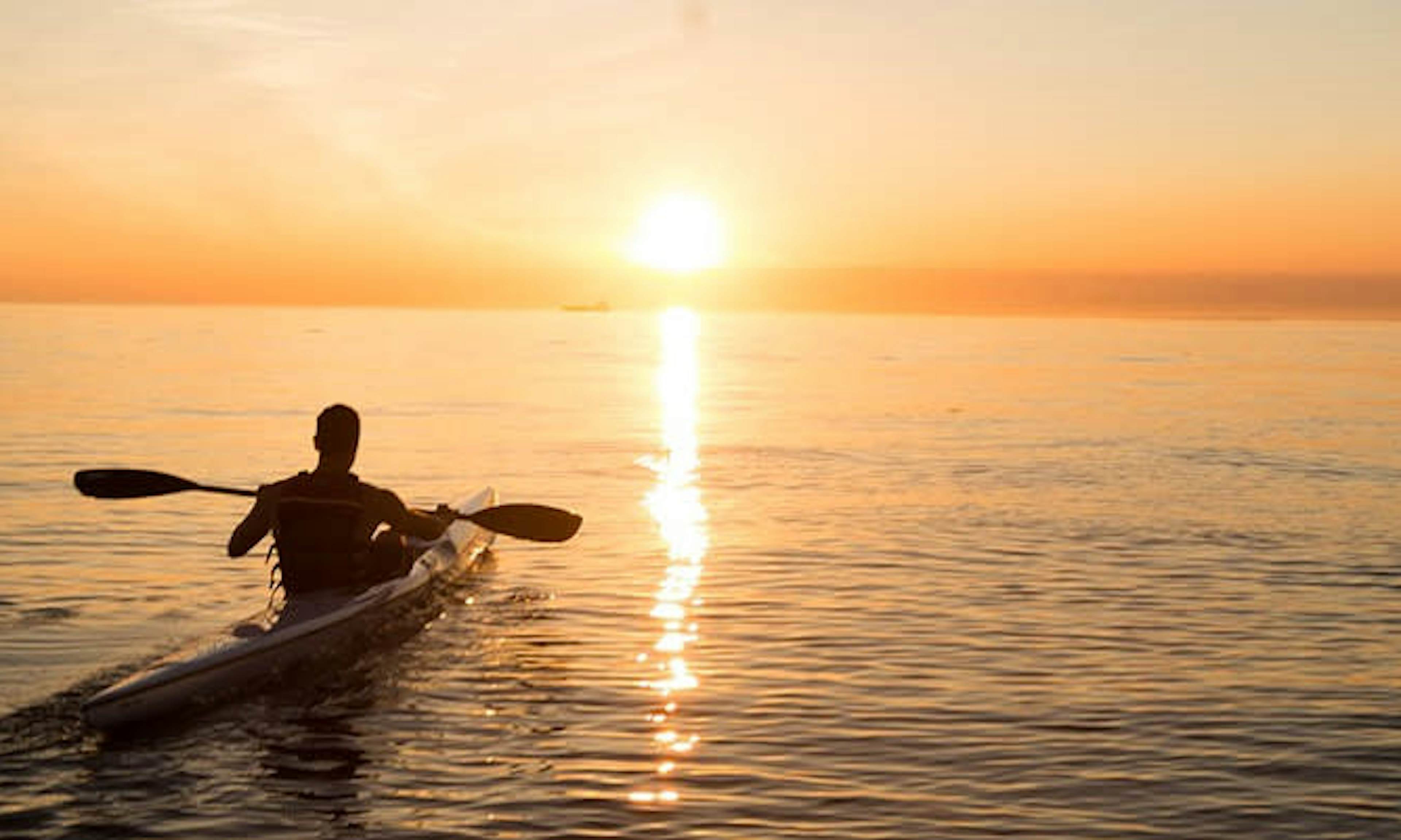 man on a kayak in the sunset