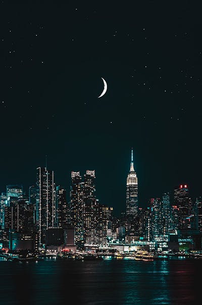 Picture of New York skyline at night with moon in sky