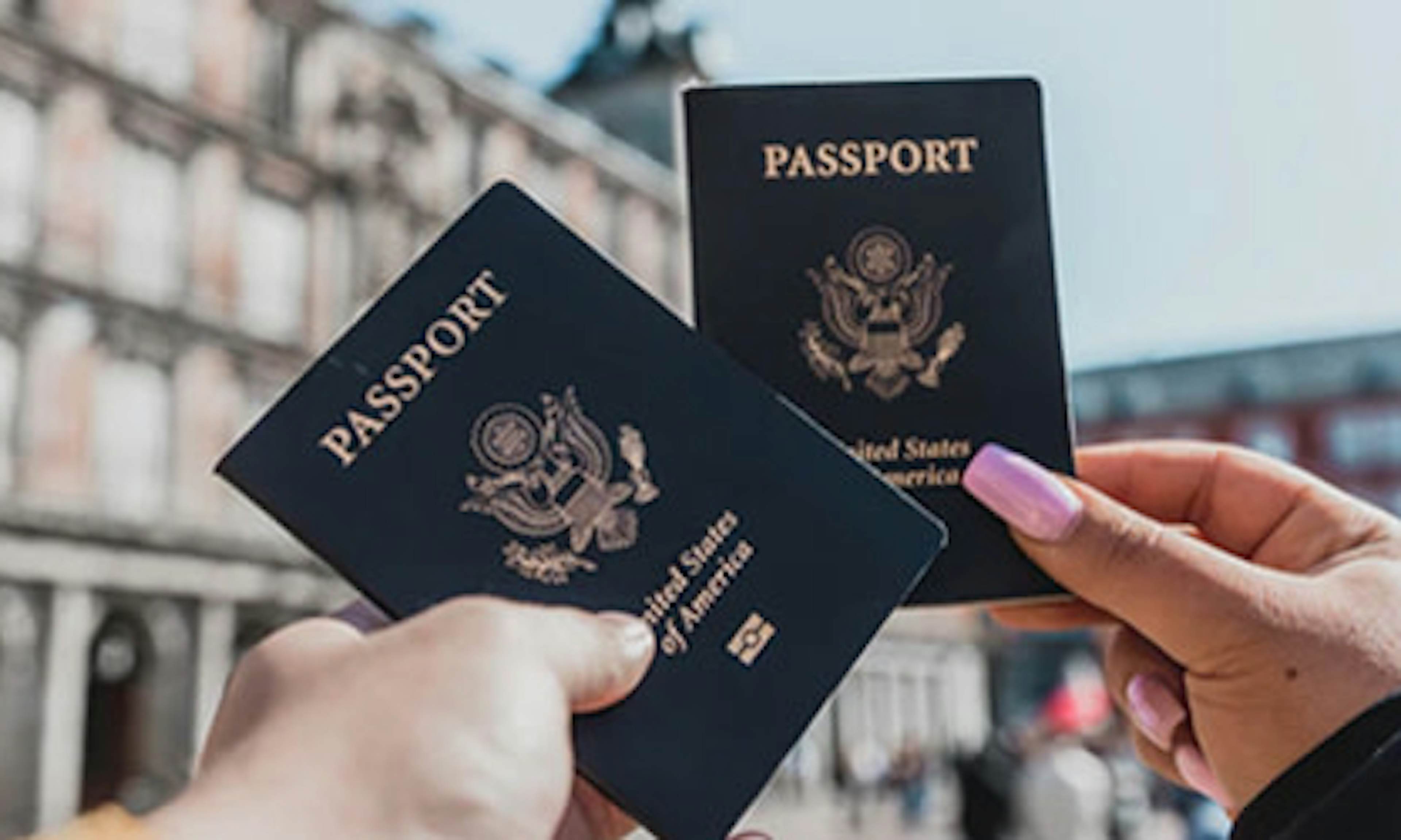 Man and women holding up 2 US passports