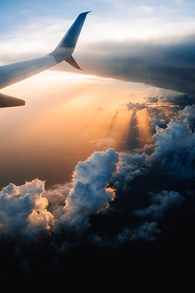 Picture of plane wing with clouds in background