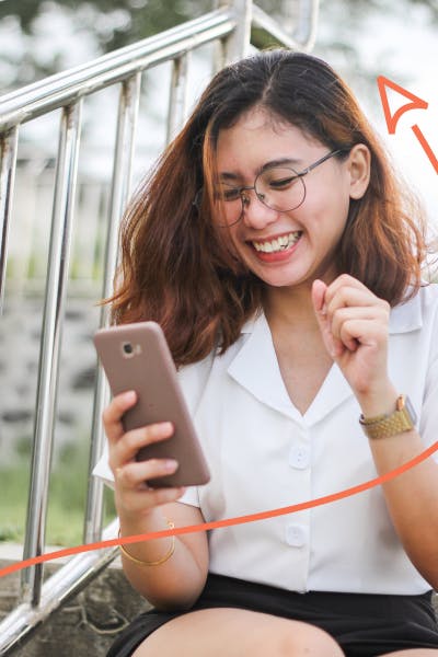 Woman laughing while looking at phone