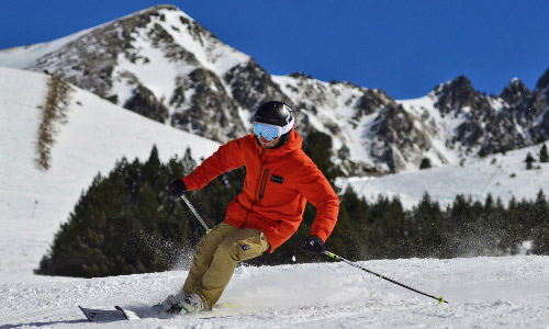 Snowy mountain slopes with sunlight coming through the trees