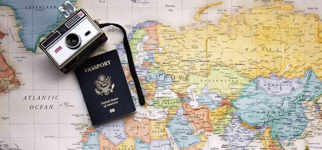 A camera and passport positioned on a large map