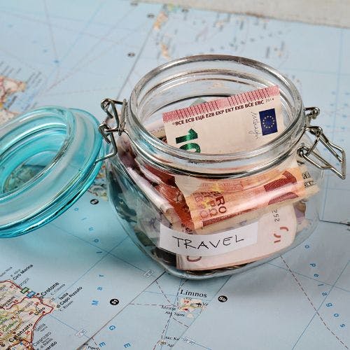 Cash inside a glass jar on a map