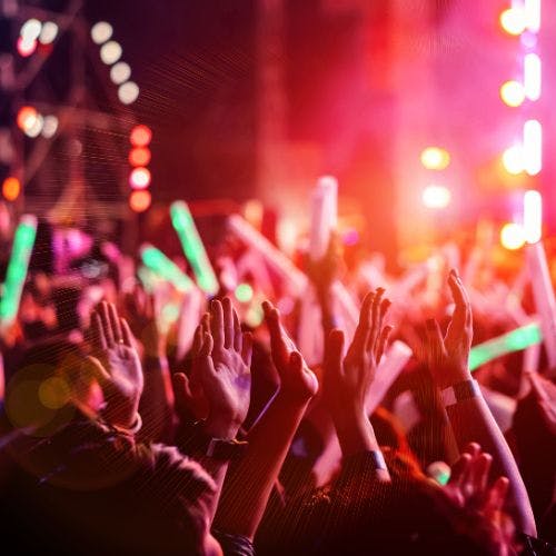 People raising their arms at a music festival