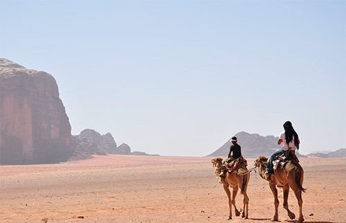 Image of two camel riders in the dessert
