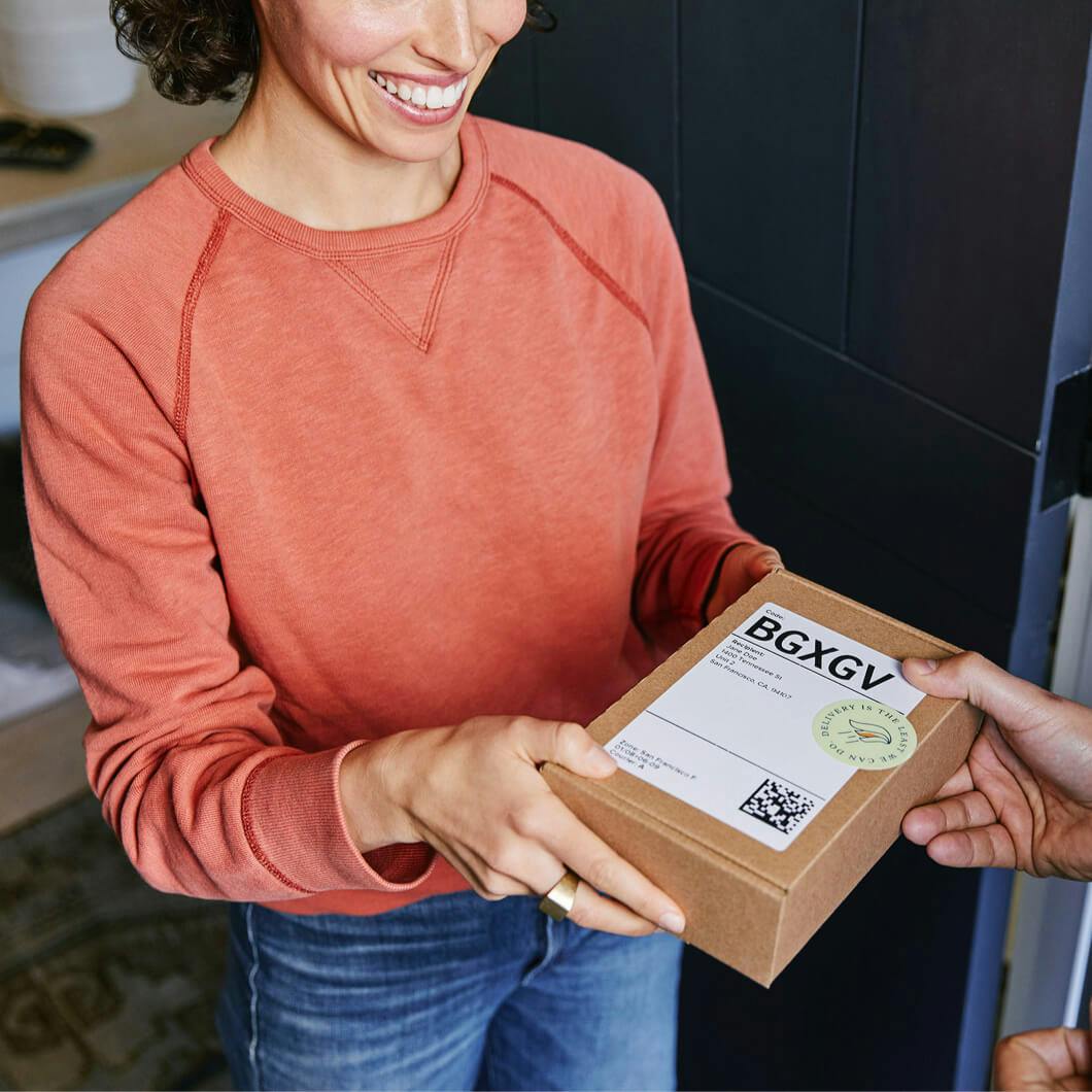 Photo of an Alto customer receiving her delivery from an Alto courier