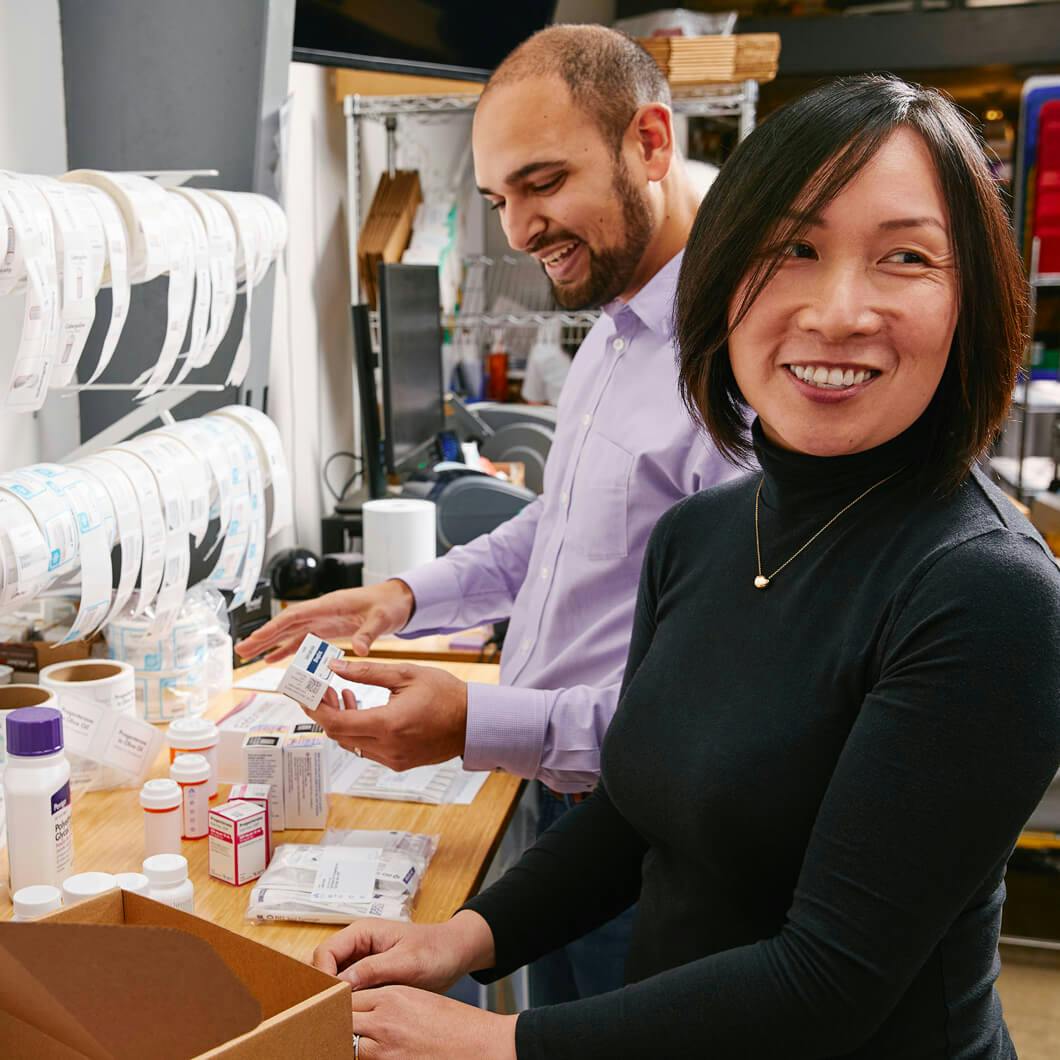 Photo of two Alto pharmacists packing deliveries