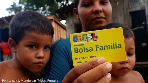 Woman holding Bolsa Familia card