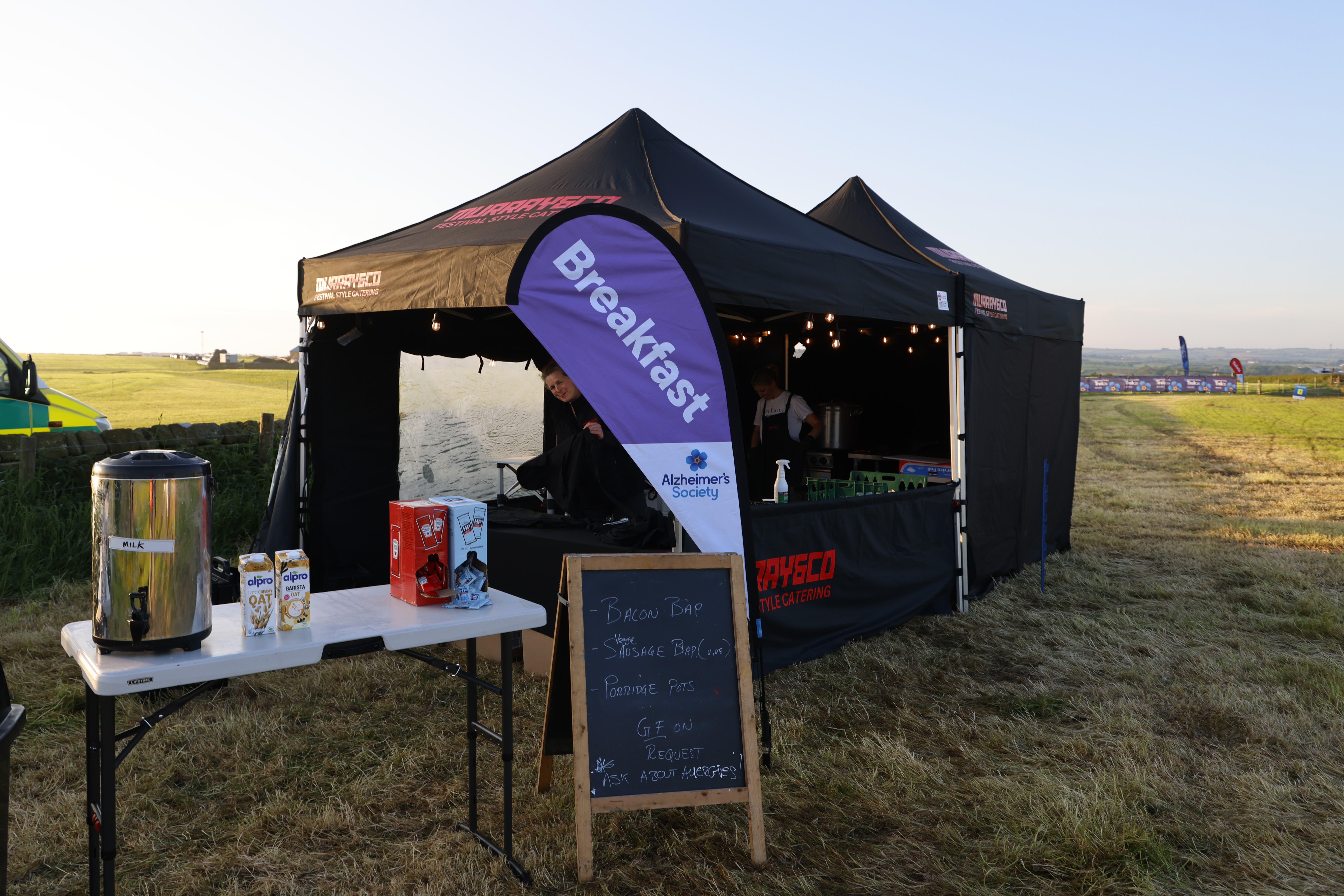 Breakfast gazebo with catering staff standing inside.
