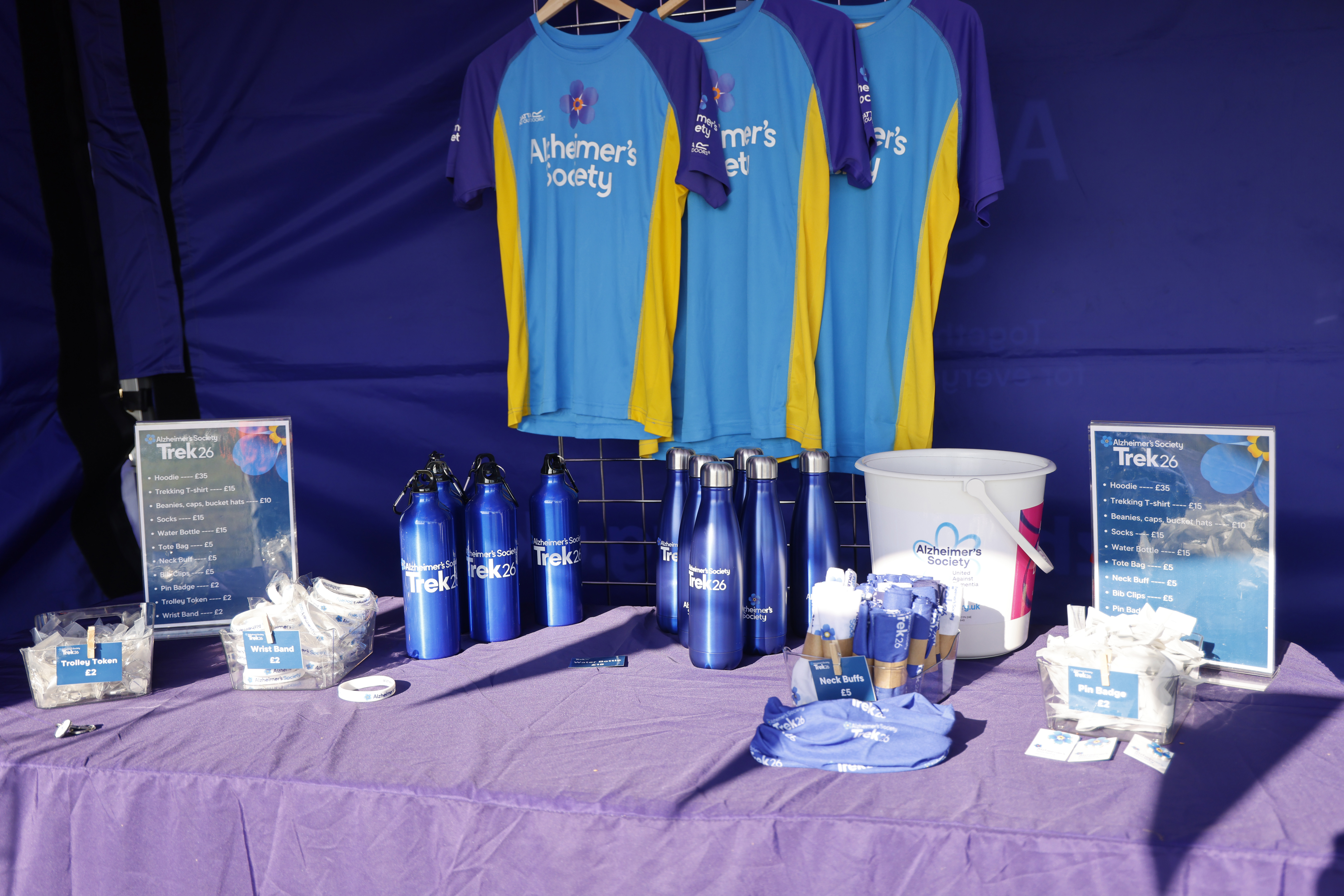 Table containing Trek26 branded merchandise, including water bottles, t-shirts and wristbands.