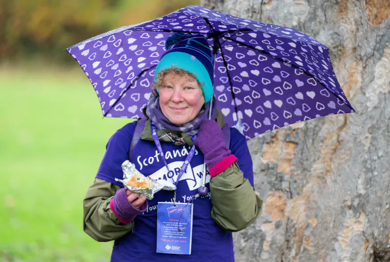 Memory walk participant smiling with umbrella