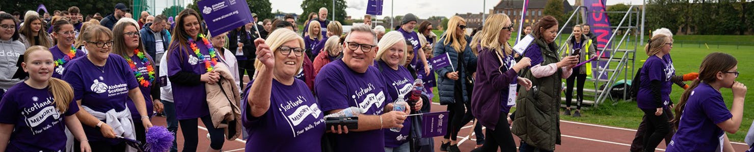 A group of walkers smiling waving flags