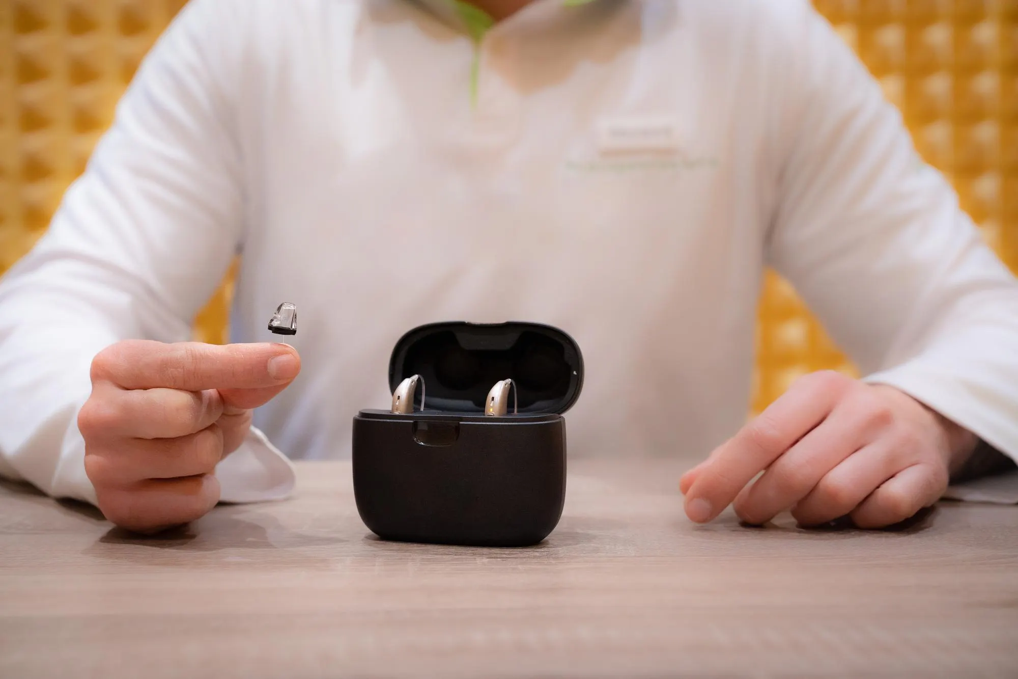 Audiologist displaying two hearing aids after cleaning them for optimal usage in Marco Island, FL