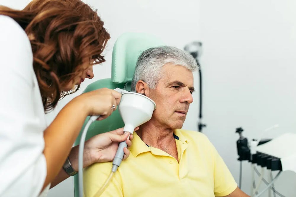 Middle-aged man getting earwax removed