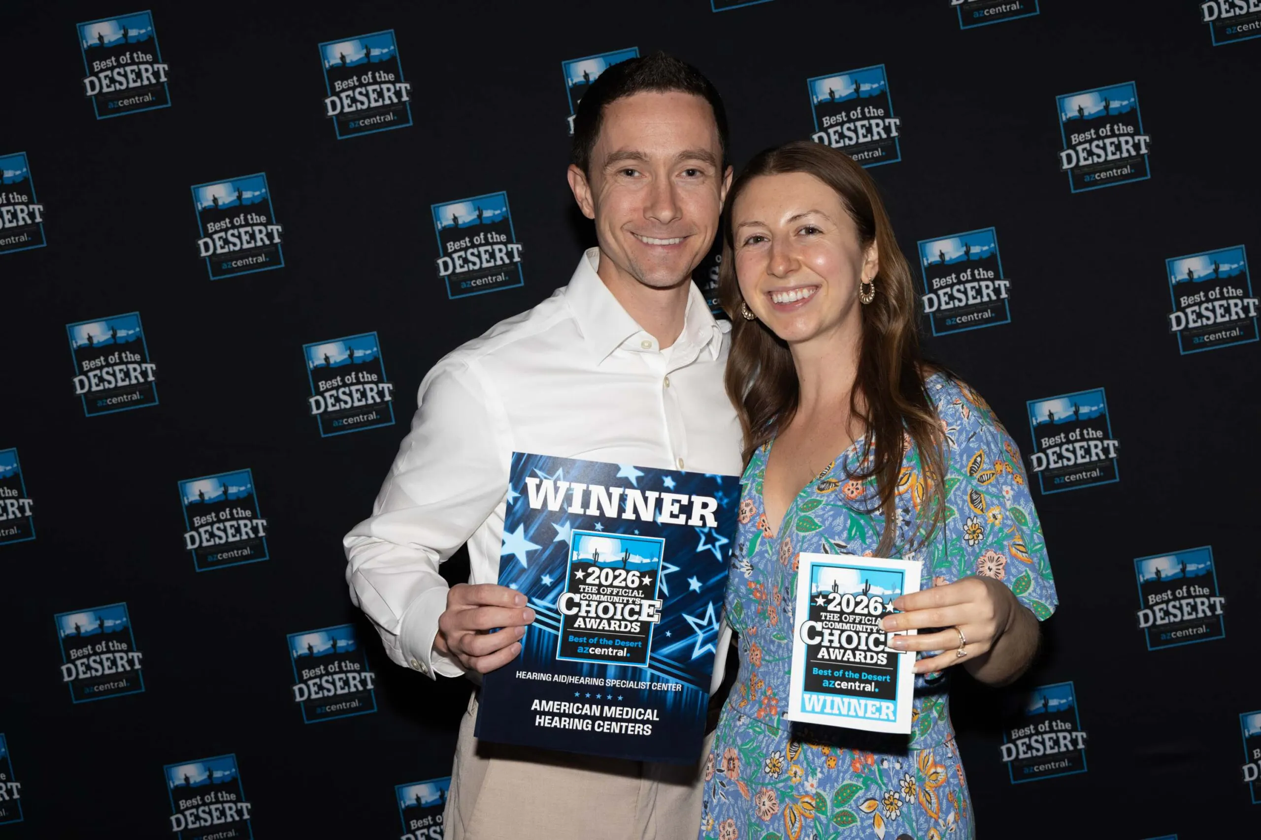 Two American Medical Hearing Centers team members holding the 2026 Best of the Desert winner awards.