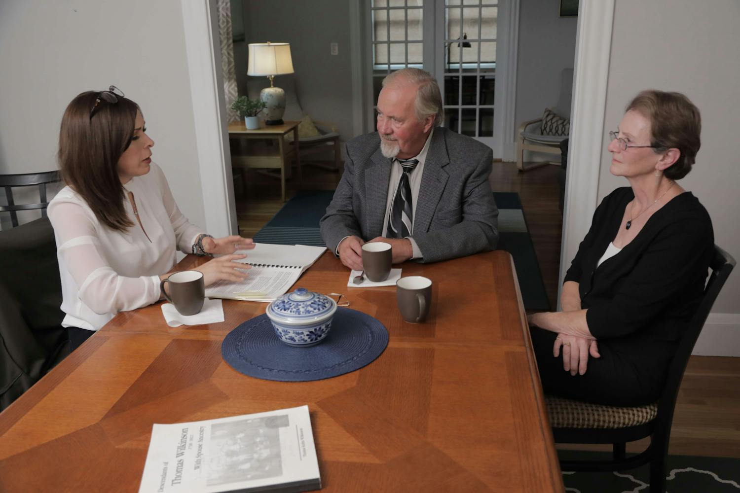 Three people sat around a table with paperwork in front of them