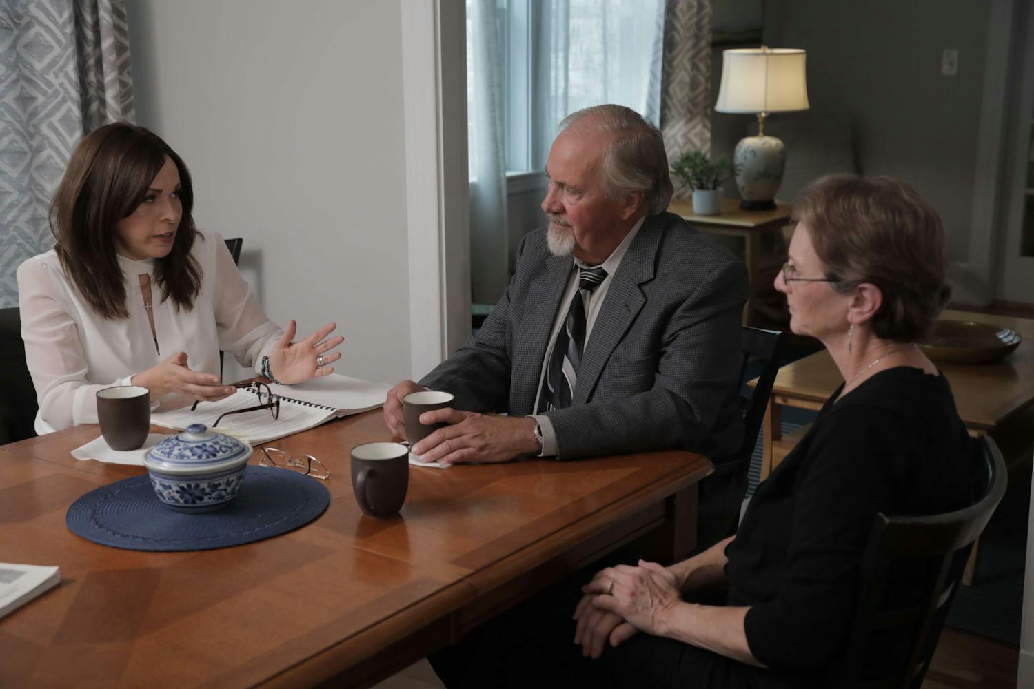 Three people sat around a table with paperwork in front of them