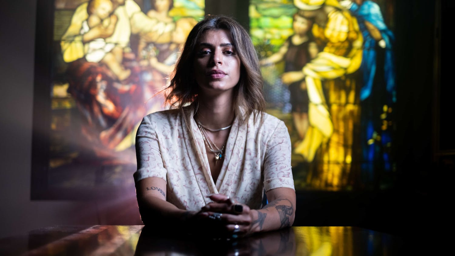 Woman being interviewed in front of stained glass window