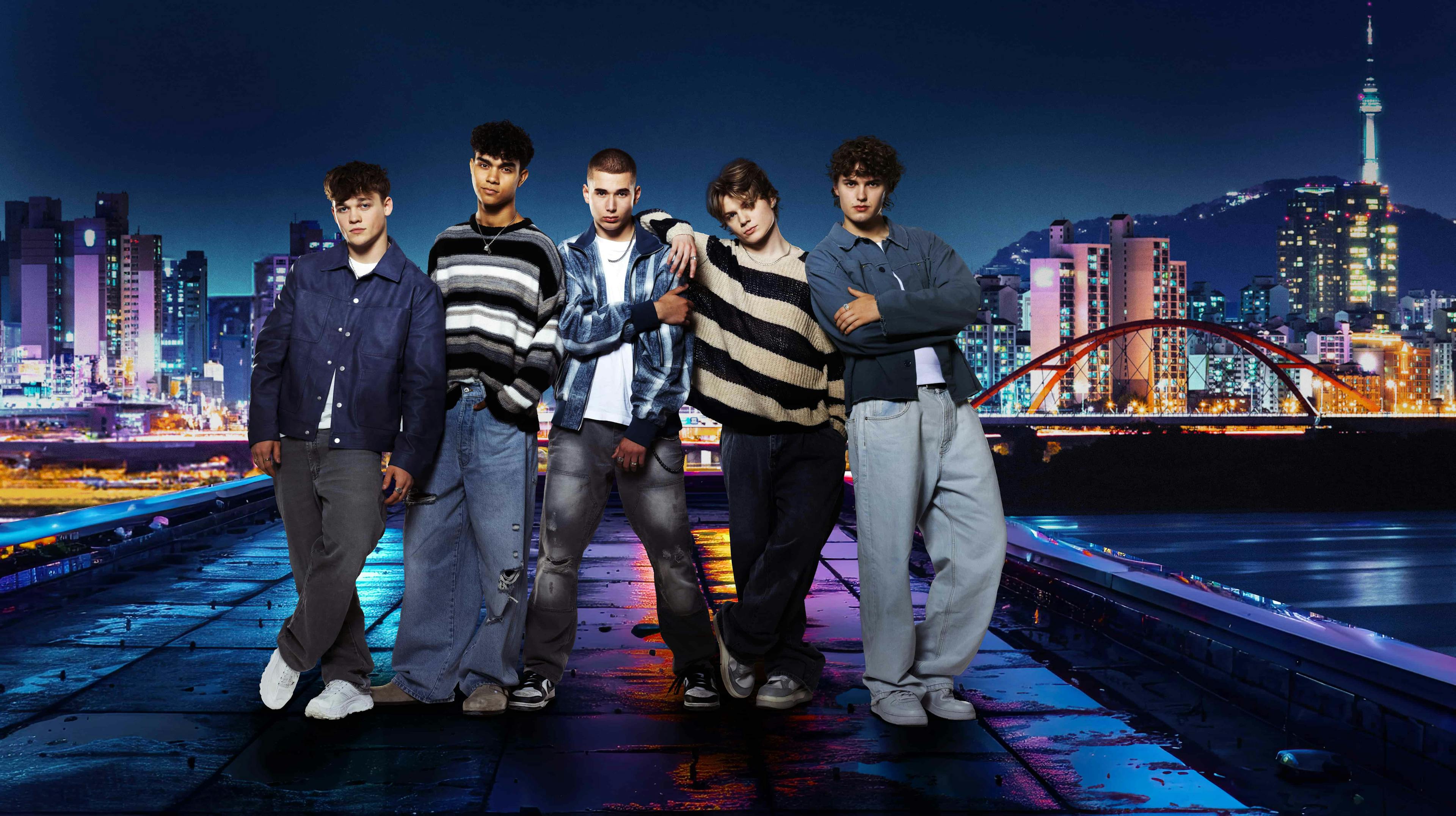 Boyband posing for camera with backdrop of Korea