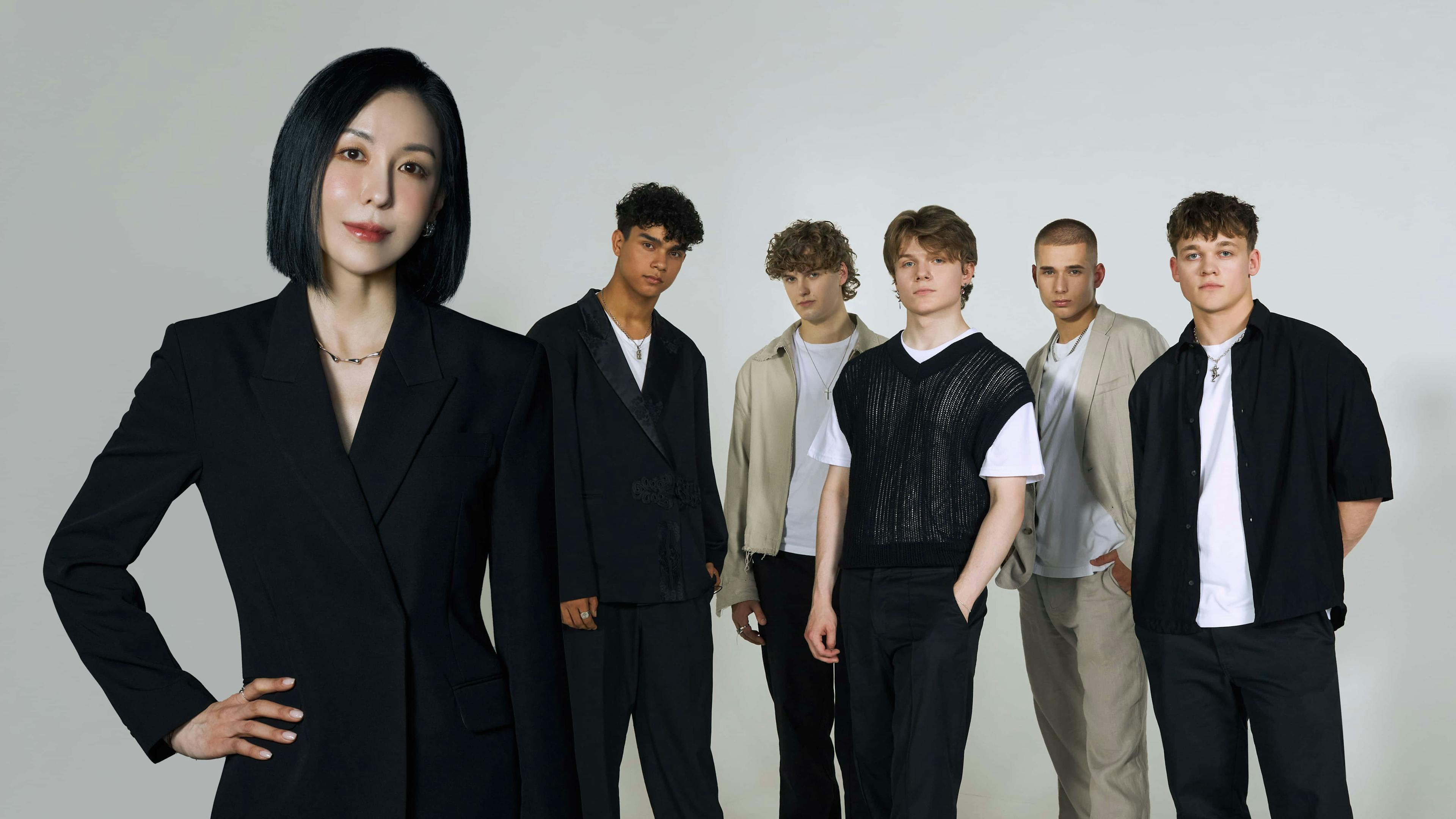 Boyband and woman stood in front of camera