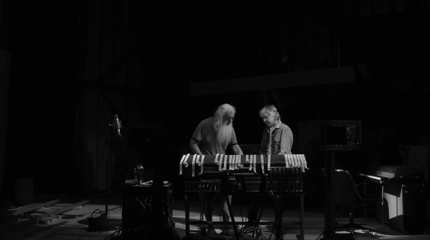 Paul McCartney and man stood next to piano