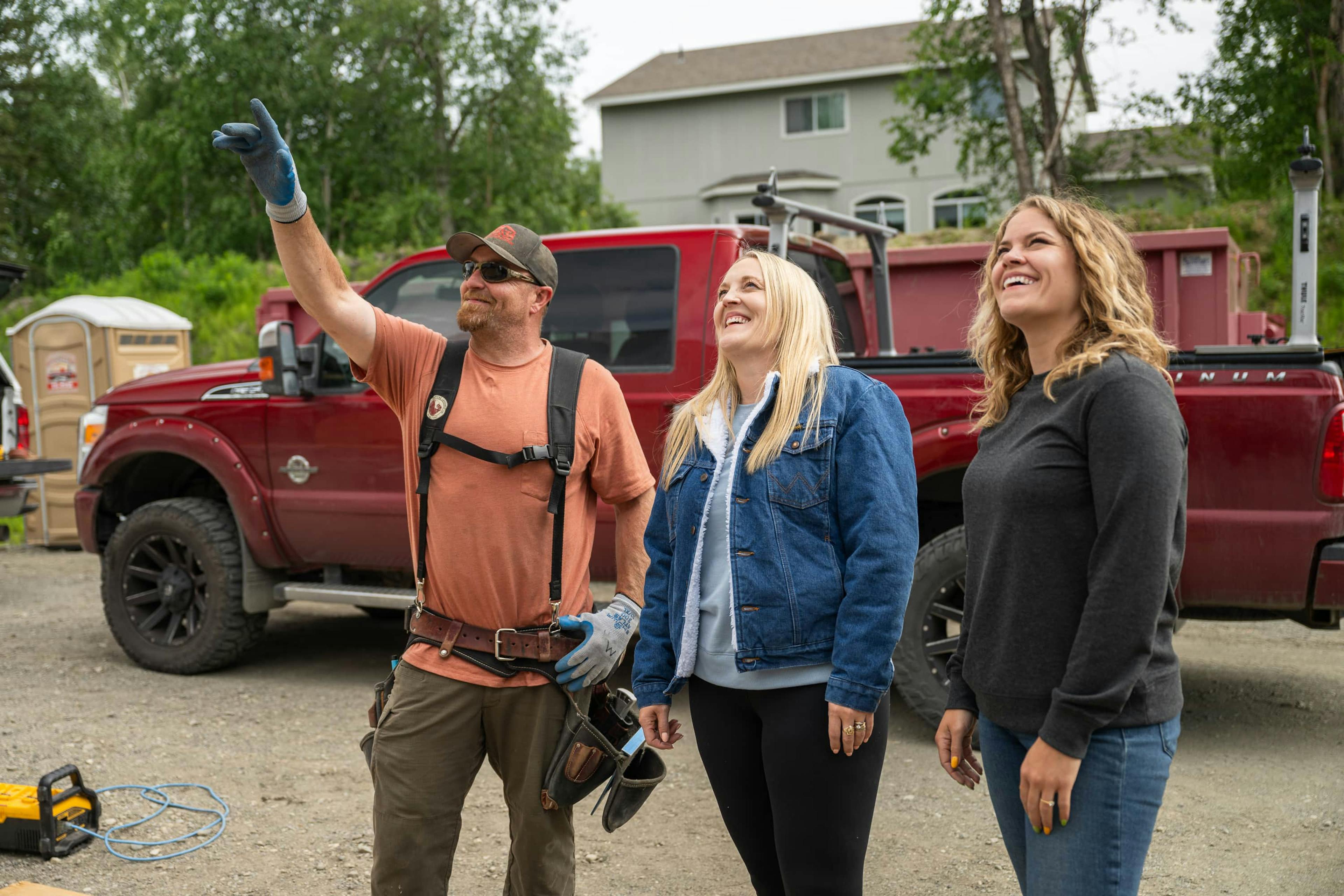 Two women and builder looking up