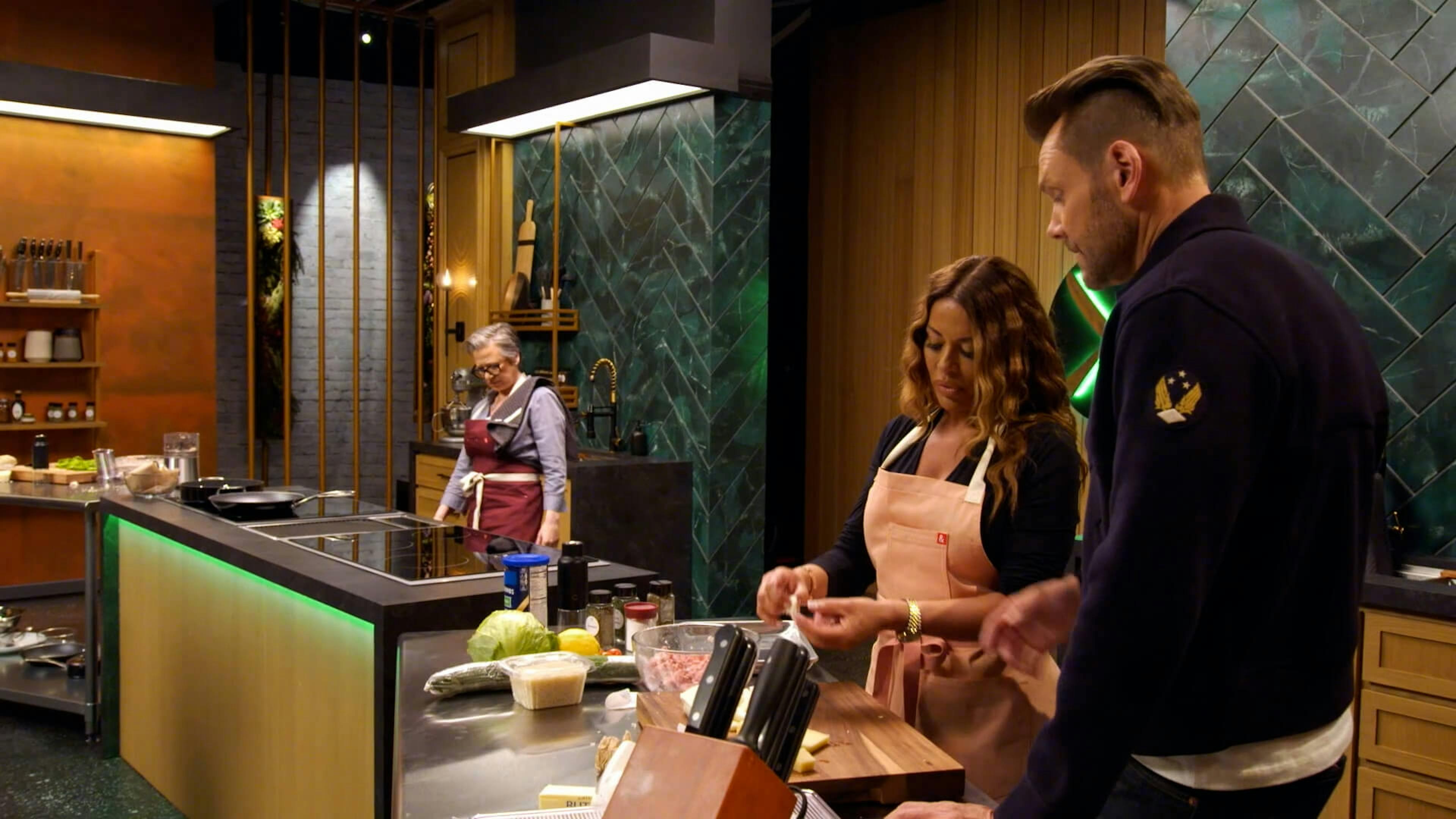 Man stood next to a woman whilst she's cooking