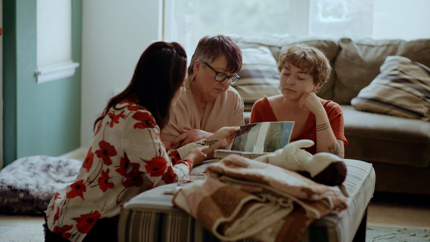 Three women looking through picture book