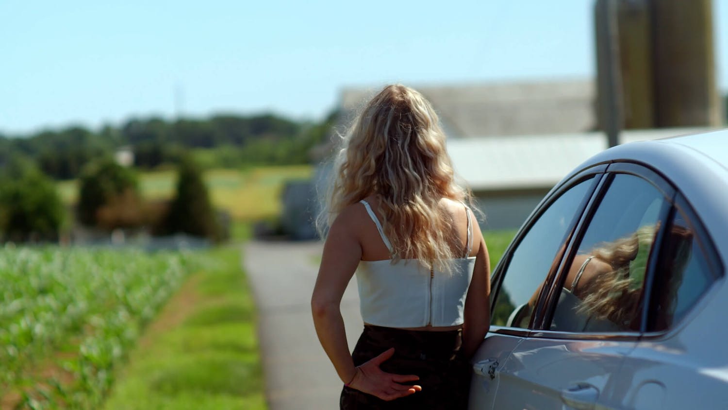 Blonde woman standing next to car