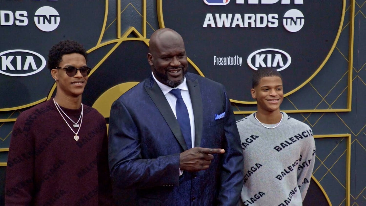 Man and two boys on red carpet