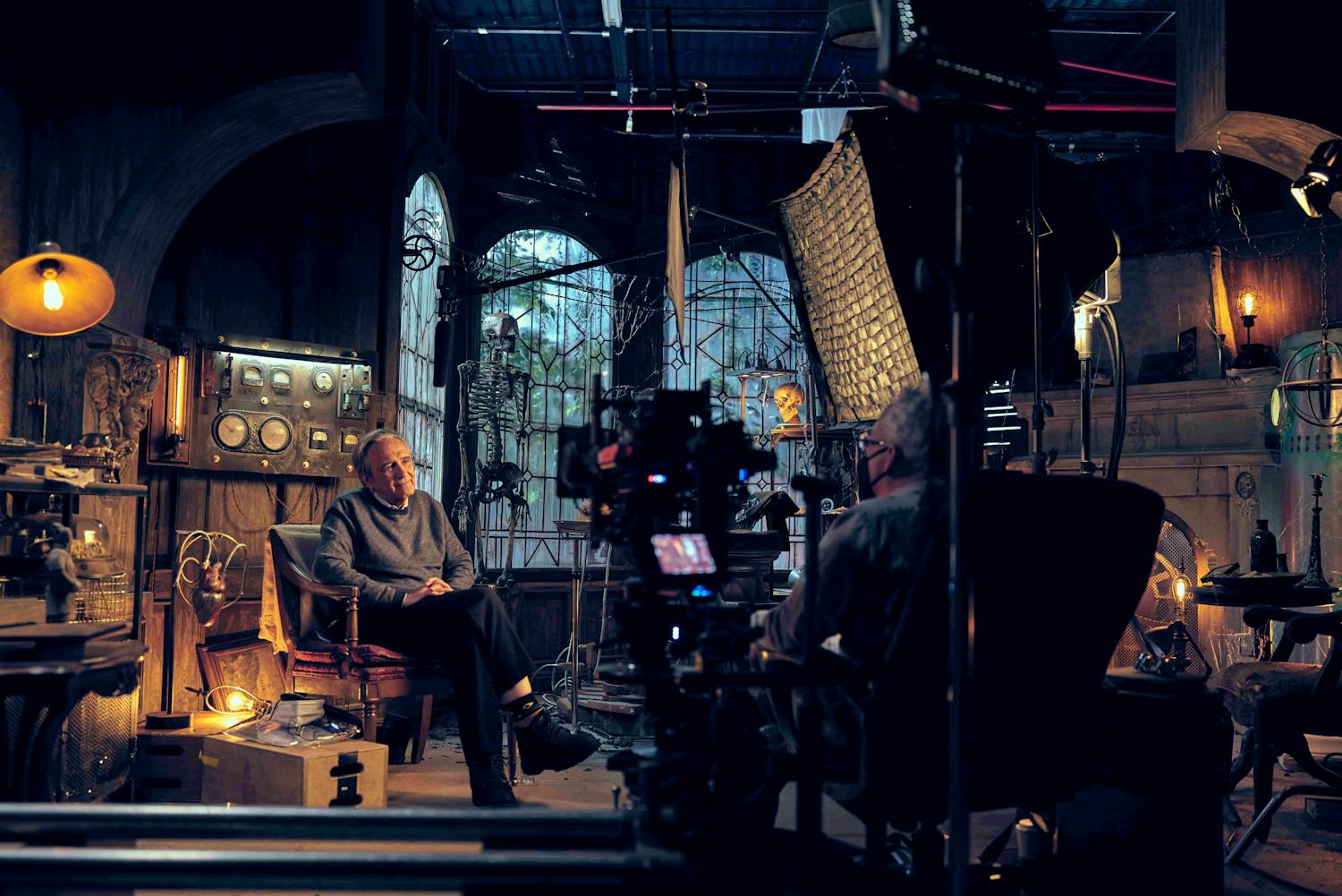 Behind the scenes shot of a man being interviewed with a horror background