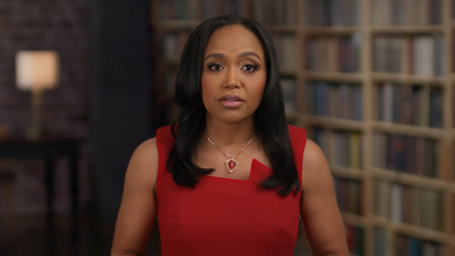 Woman being interviewed in front of book shelf