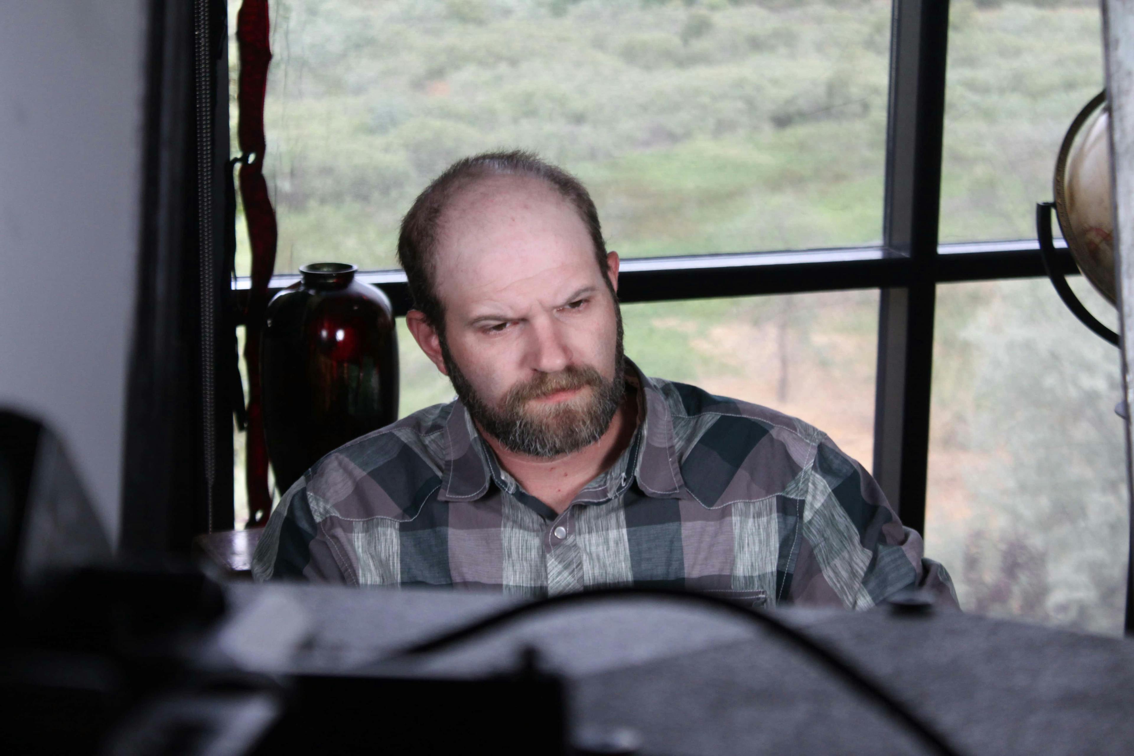 Man being interviewed in front of window