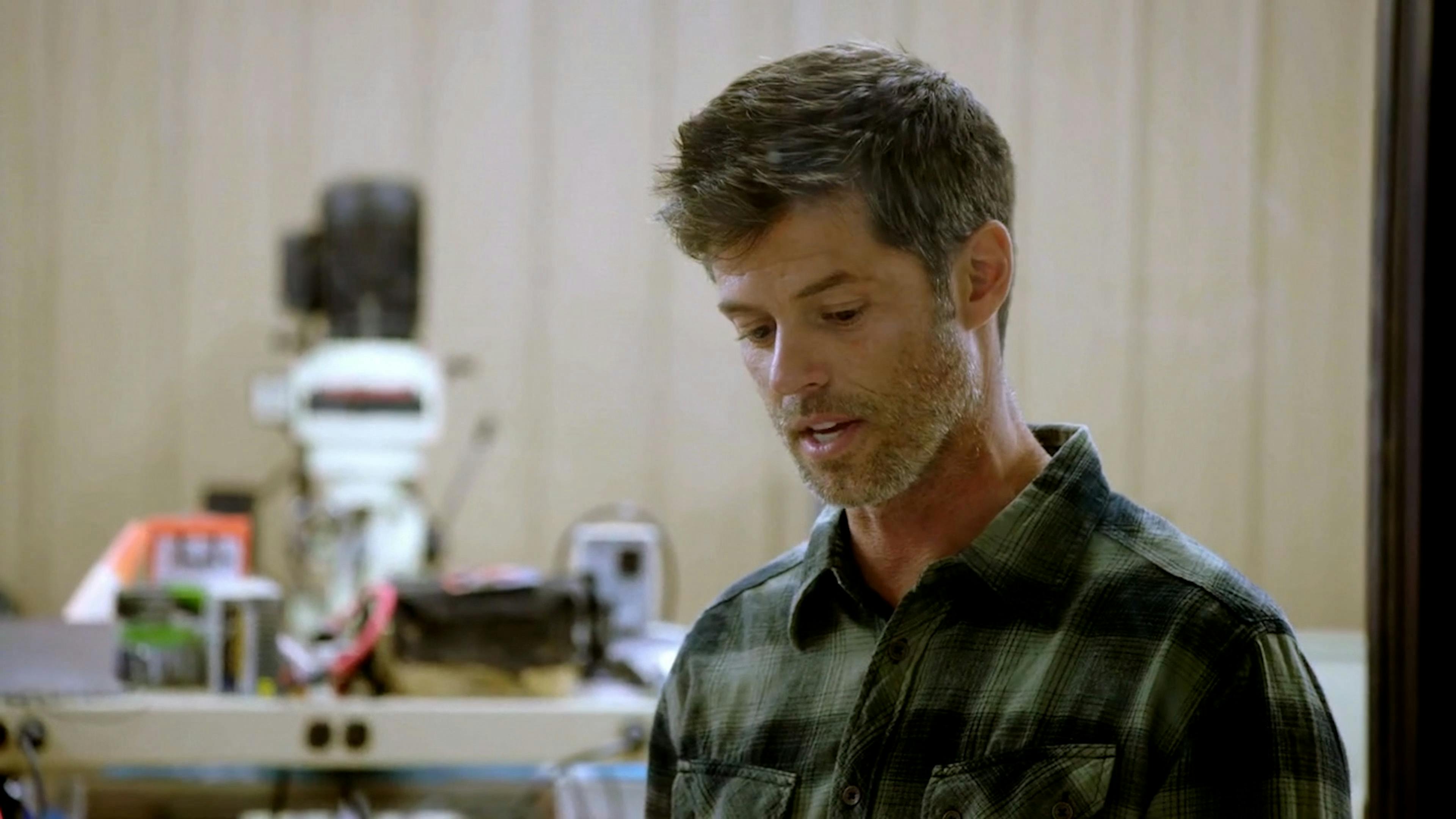 Man talking in front of a machine