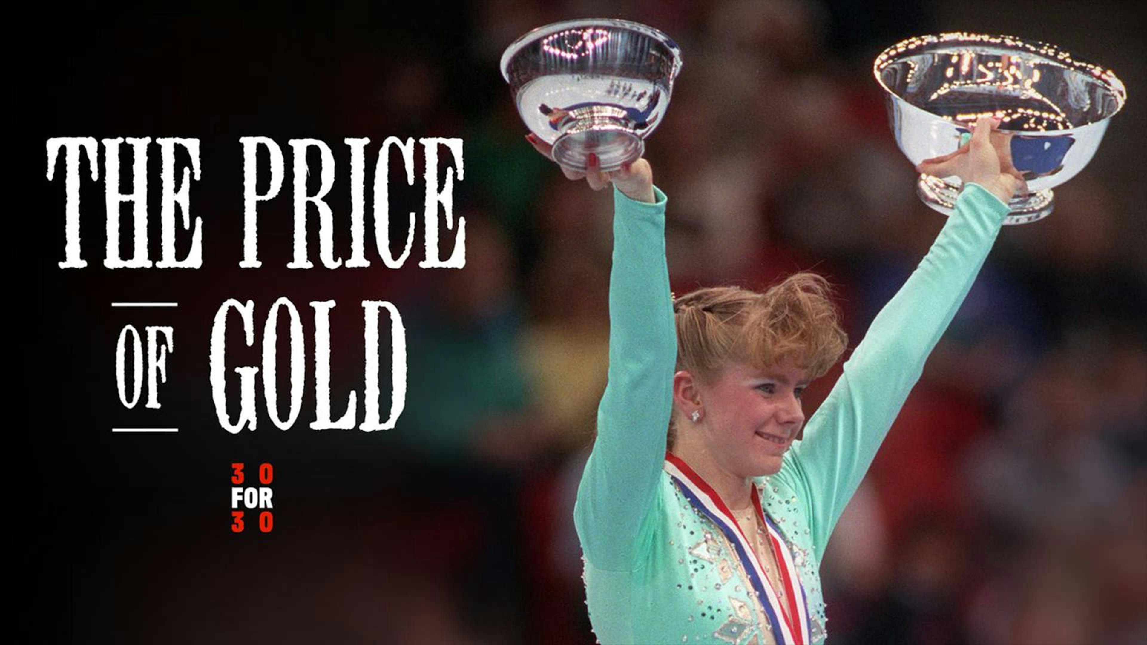 Ice skater holding up 2 trophies