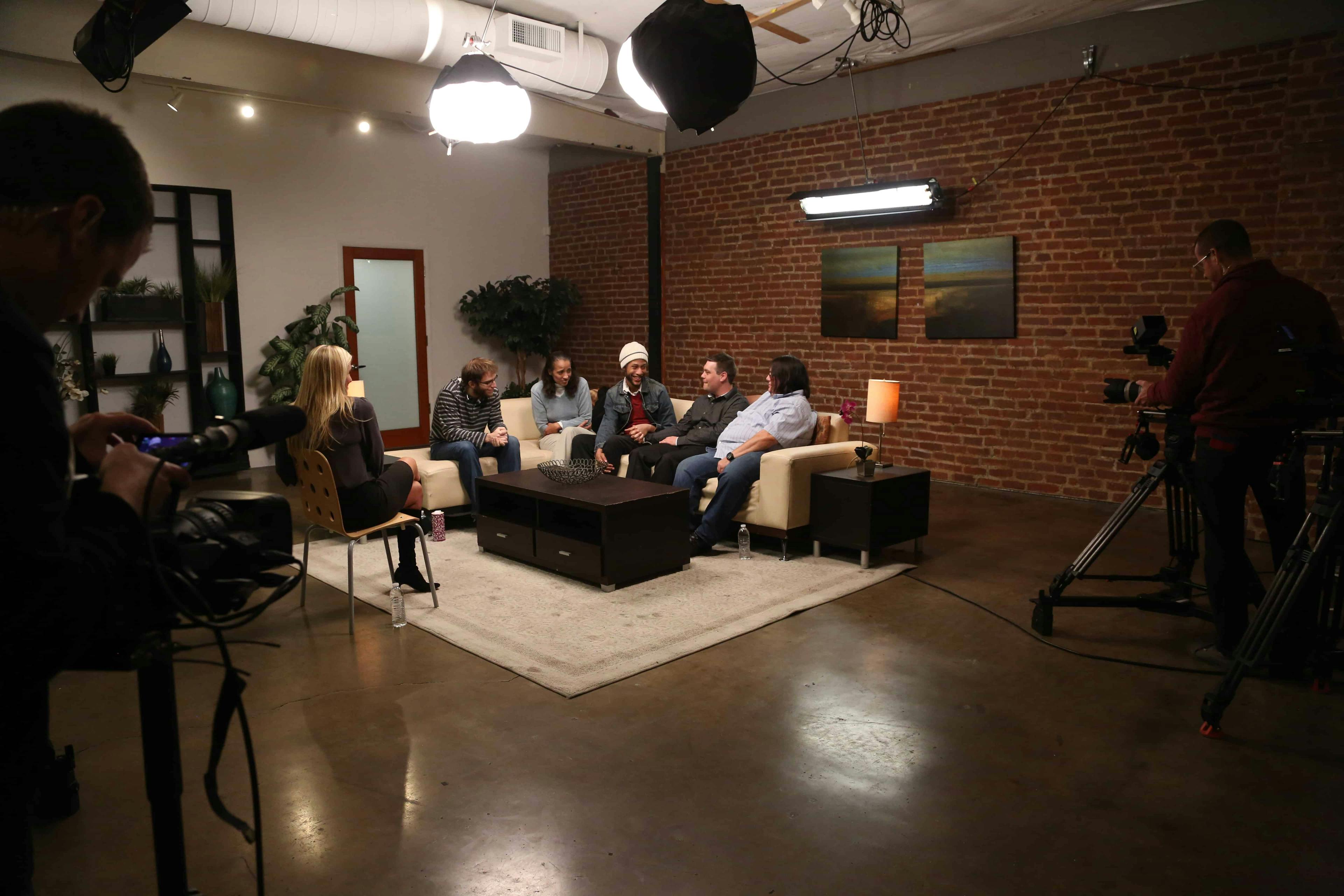 Room of people sat on sofa in studio