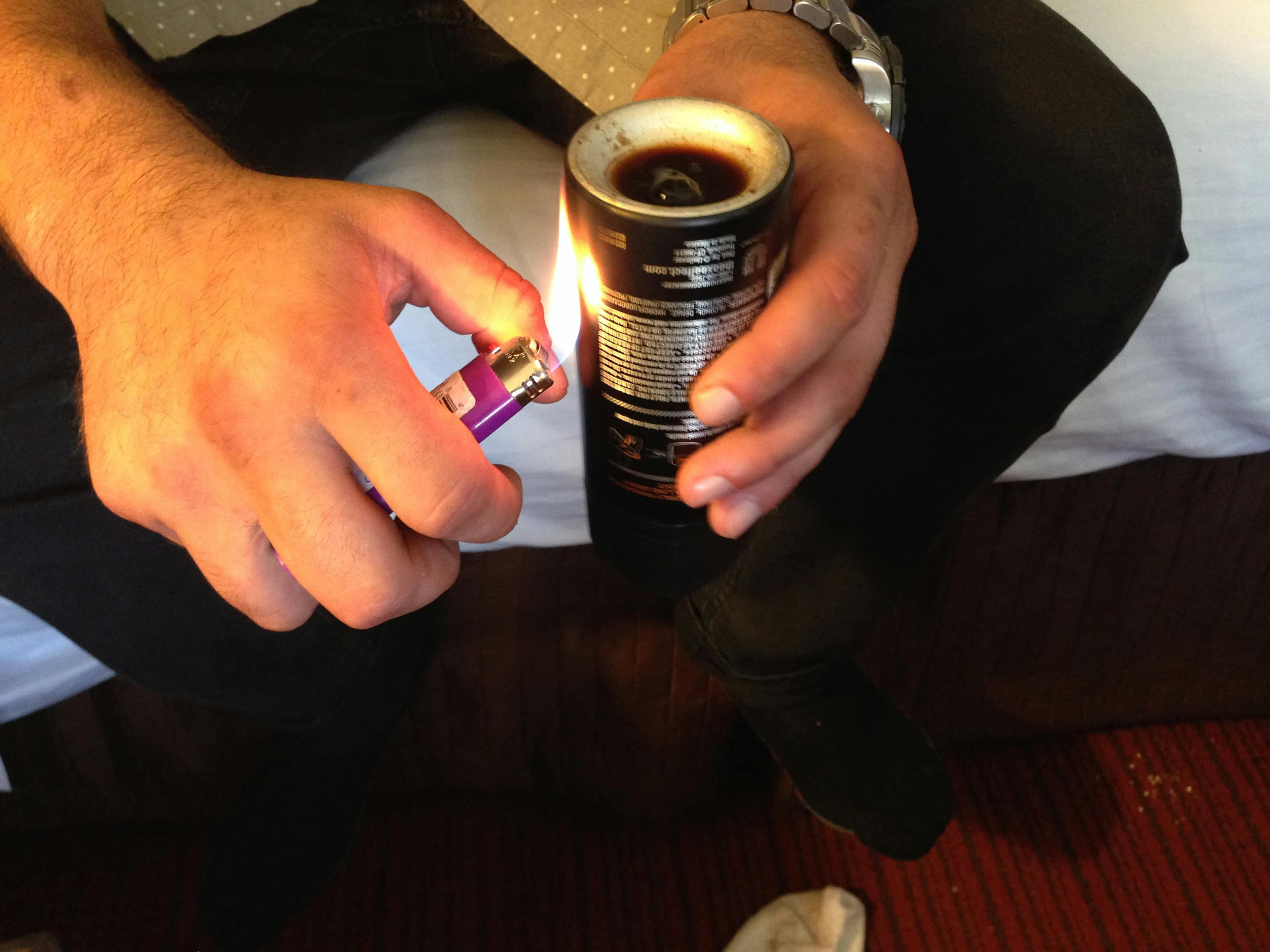 Man with lighter held next to a can