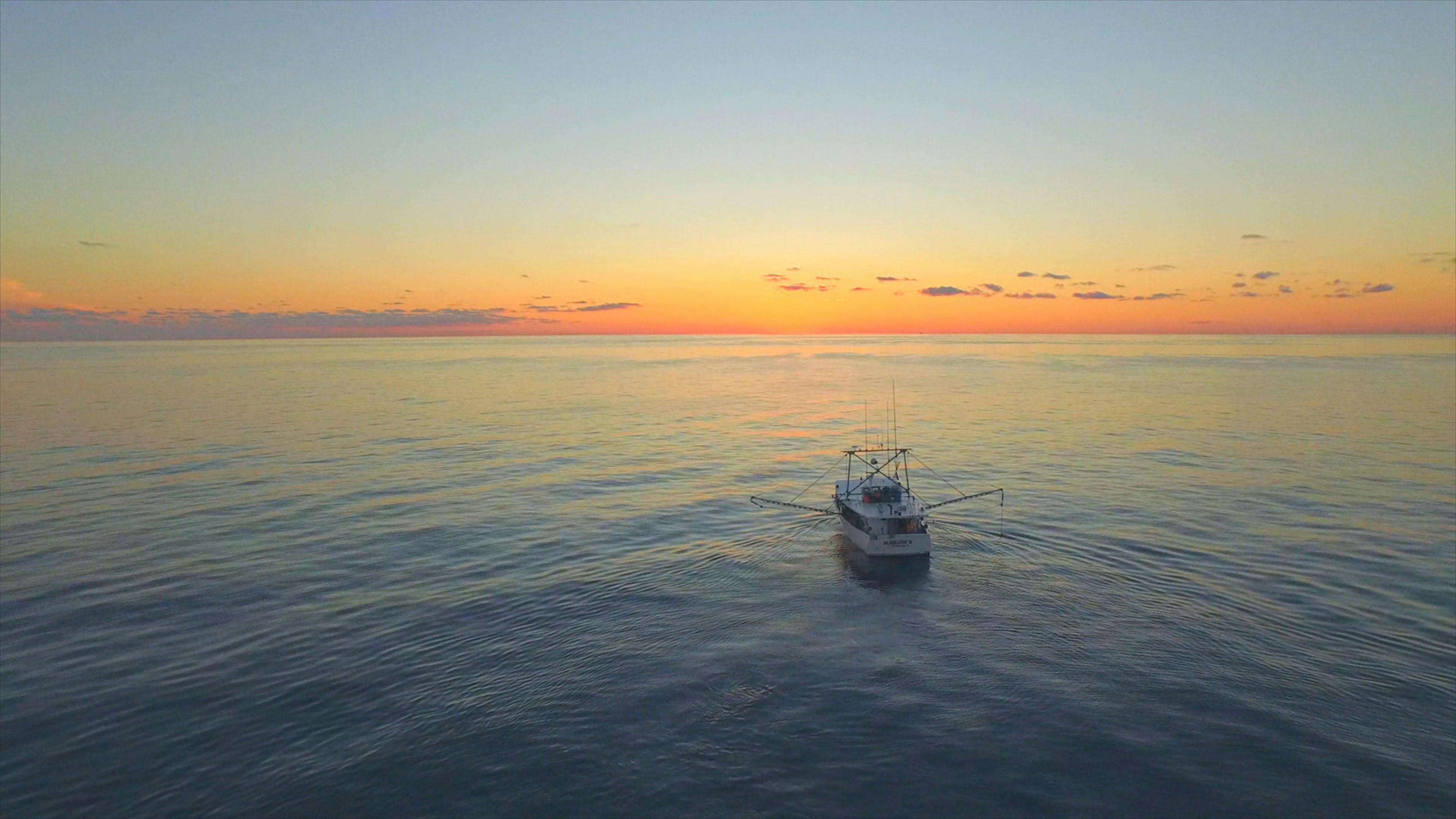 Fishing boat at sea during sunset