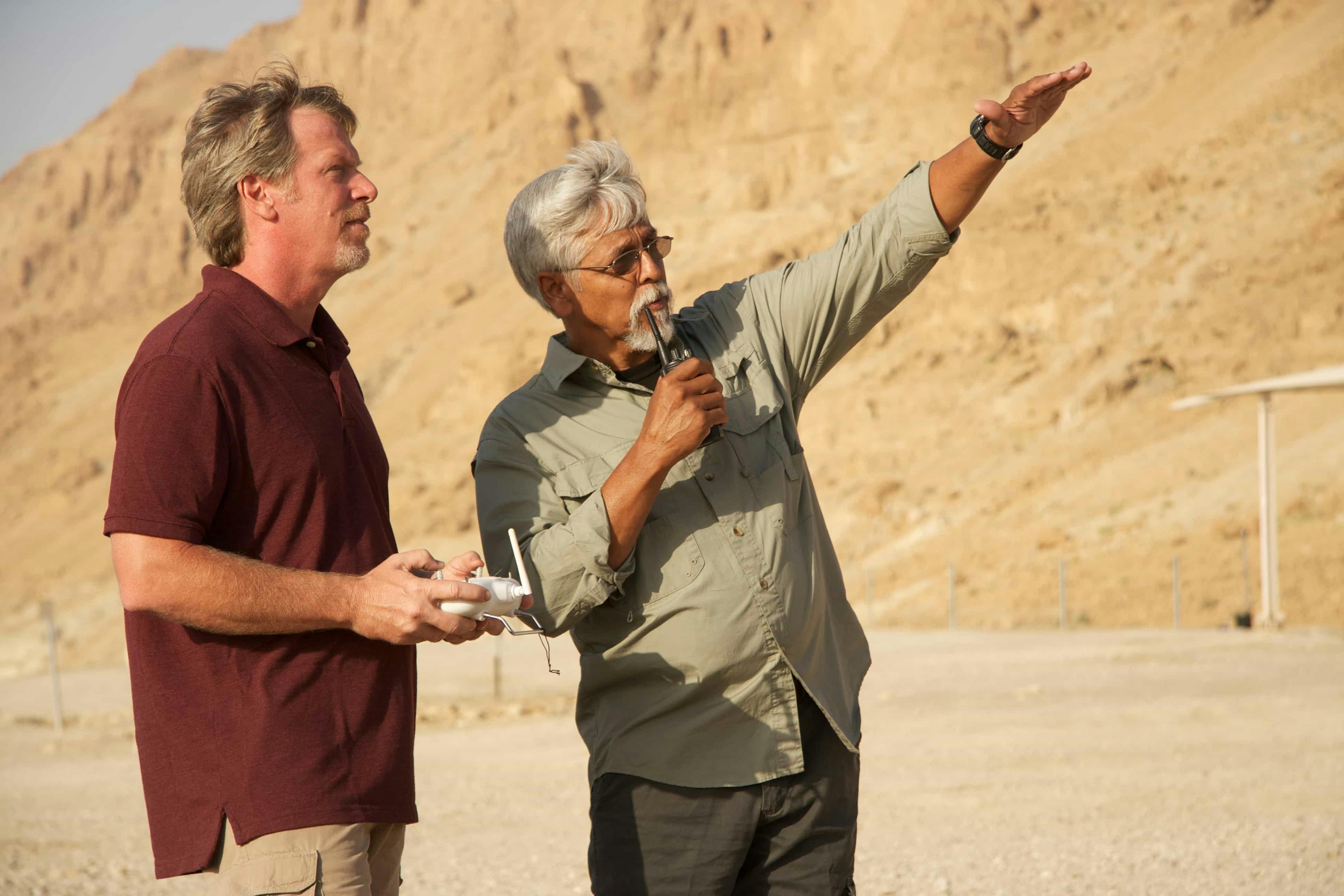 Man pointing in the air showing another man something