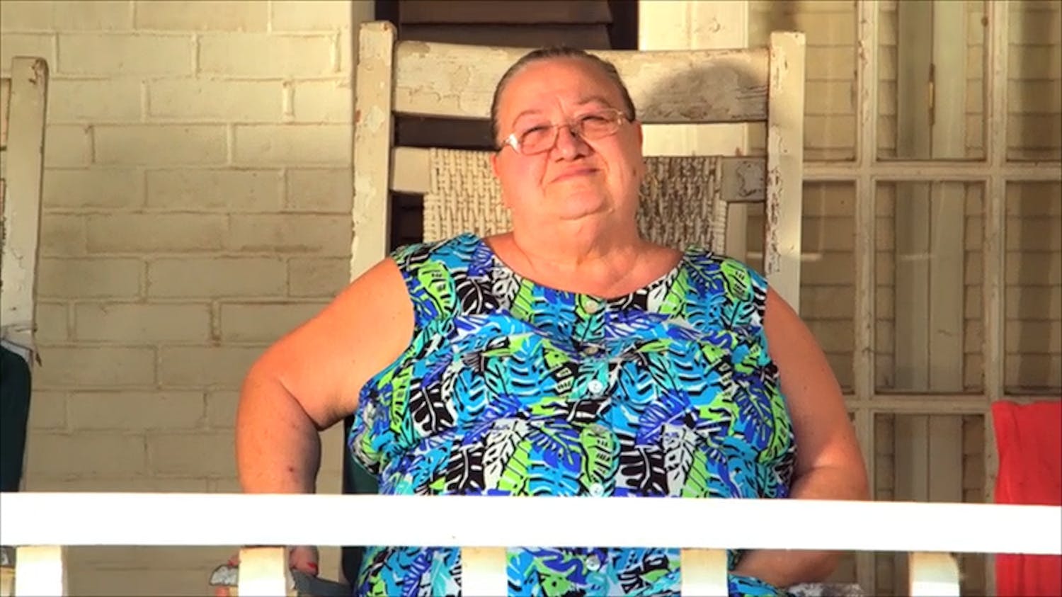 Woman sat on chair outside house