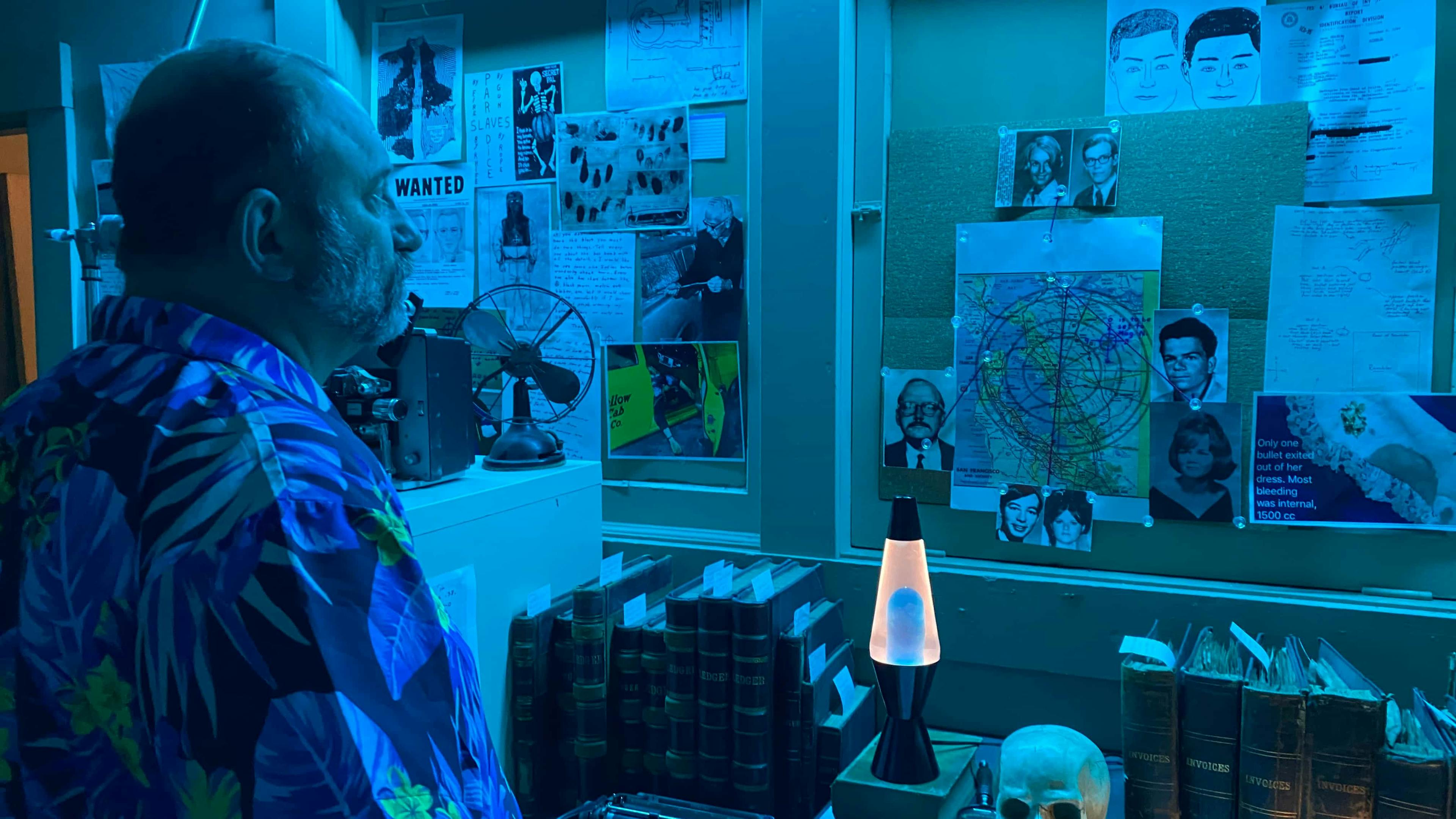 Man looking at notice board with suspects faces on