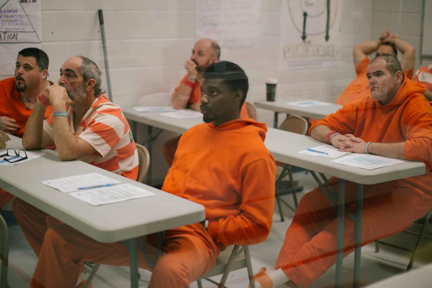 Male prisoners sat at desks in classroom